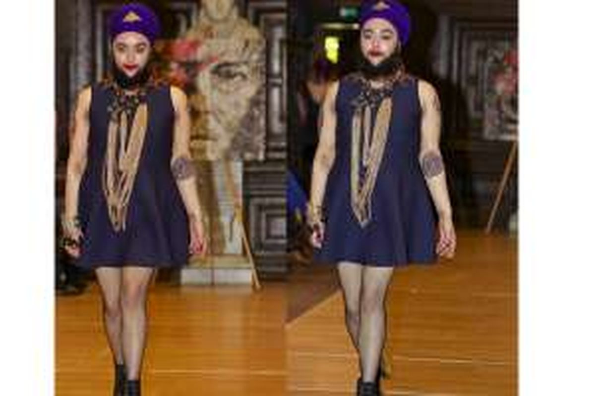 Harnam Kaur melenggang sebagai model di panggung runway mengenakan busana terusan selutut yang anggun. 