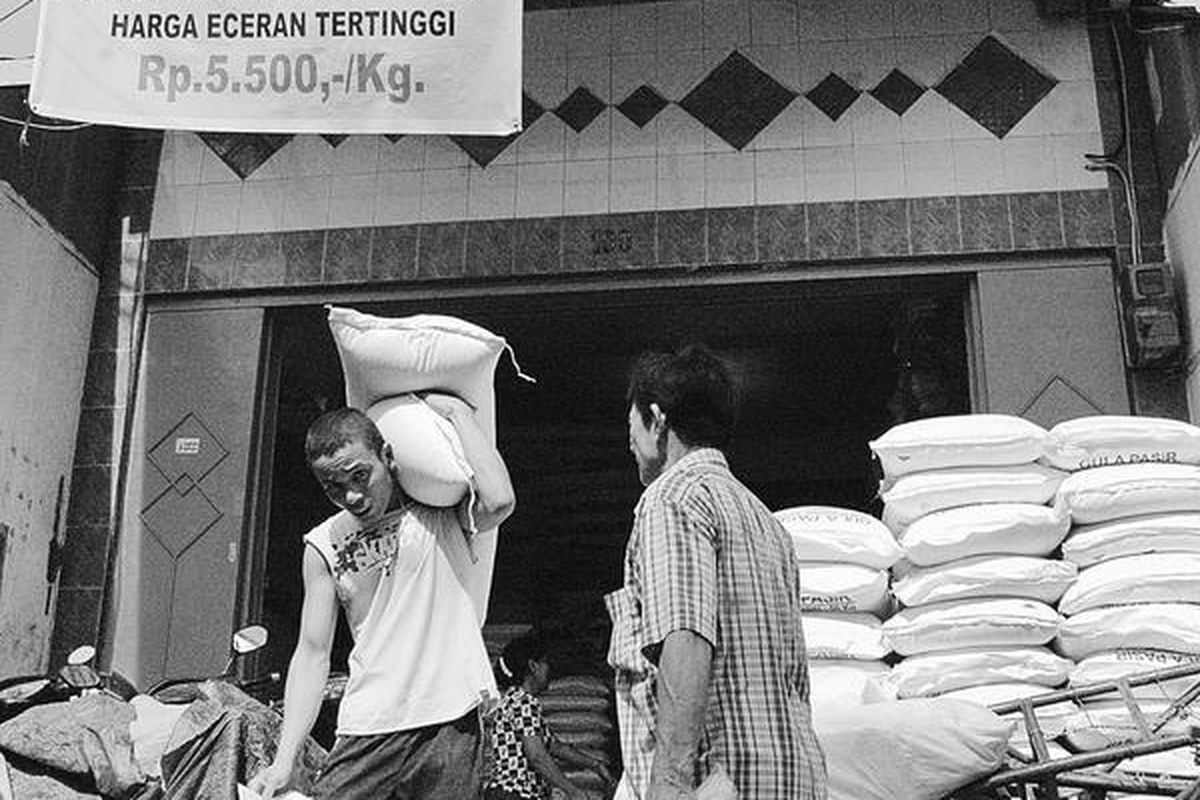 Seorang pekerja memanggul bahan pokok di toko yang menjual beras Perum Bulog di kawasan Pasar Pringgan, Medan, Rabu (25/8). Perum Bulog telah menggelontorkan 30 ton beras dalam operasi pasar sejak Jumat pekan lalu. Namun, gelontoran belum menurunkan harga.