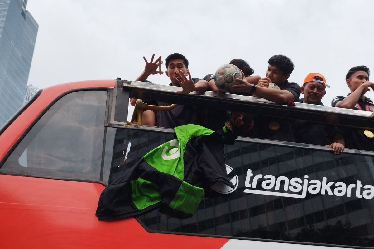 Gelandang Timnas sepakbola U-22 Taufany Muslihuddin melempar kembali jaket yang baru saja ditandatanganinya saat konvoi Kira8 7uara di Bundaran HI, Menteng, Jakarta Pusat, Jumat (19/5/2023). (KOMPAS.com/XENA OLIVIA)