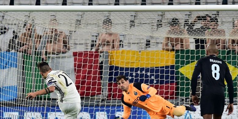 Penyerang Juventus dari Argentina Paulo Dybala (kiri) mencetak penalti melawan kiper Spanyol Porto, Iker Casillas selama pertandingan sepak bola Liga Champions UEFA Juventus vs FC Porto pada 14 Maret 2017 di stadion Juventus di Turin.