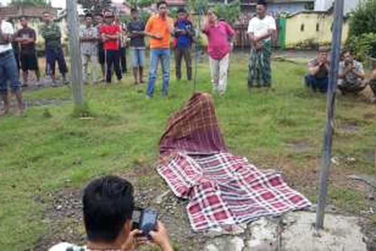 Jasad Andi Muslimin (17) tengah ditutupi sarunng sesaat setelah ditemukan tewas tergantung di tiang bendera. Selasa, (21/06/2016).