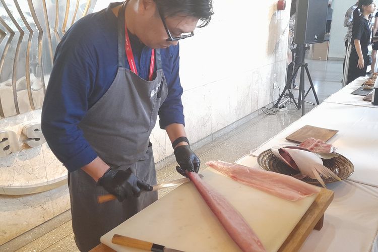 Naoyuki Shimada, Executive Chef Okuzono Japanese Dining saat memfilet ikan yellowtail.
