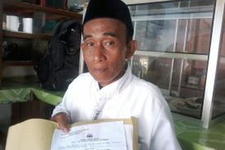 Muhidin (53), warga Desa Yosorati, Kecamatan Sumberbaru, Jember Jawa Timur, menunjukkan tanda bukti laporan dari Mapolres Jember, atas kasus penganiayaan yang dialami cucunya, Solihin, yang dilakukan orang tuanya Sahur, Senin (29/12/2014).