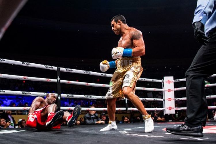 Evander Holyfield (kiri) terjatuh setelah mendapat serangan bertubi-tubi dari Vitor Belfort (kanan) pada duel tinju yang dihelat di Hard Rock Live, Hollywood, Florida, Amerika Serikat, Minggu (12/9/2021) pagi WIB.