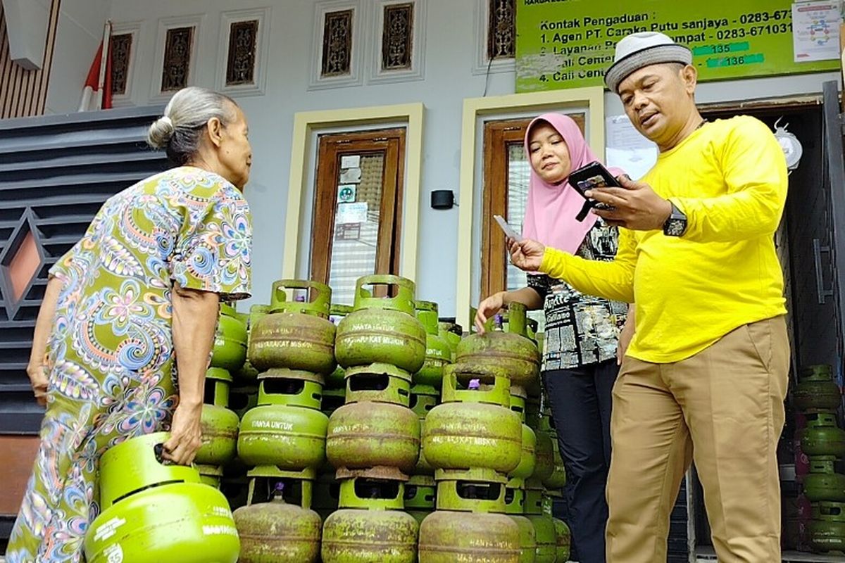 Konsumen membeli gas elpiji 3 Kg menggunakan fotocopy KTP yang langsung dicek melalui aplikasi handphone oleh penjual di pangkalan gas di Jalan MT Haryono, Kabupaten Brebes, Jawa Tengah, Senin (3/6/2024).