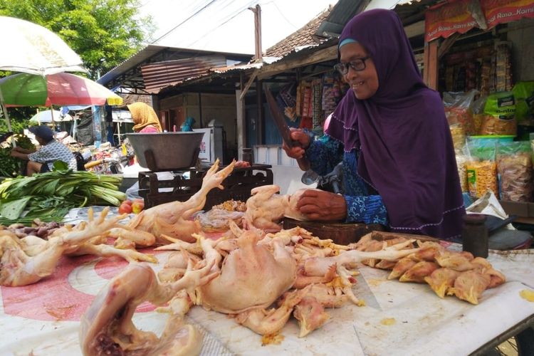Sutami, penjual daging ayam di Pasar Legi Jombang Jawa Timur, saat melayani pembeli ayam di lapak miliknya, Jumat (20/12/2019).