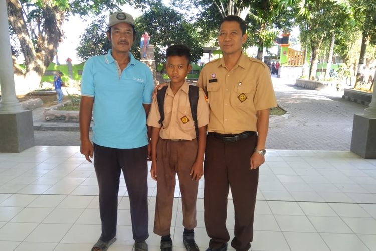 Rama Hakim Surya Alama (13) diantar ayahnya Agung Setyo Hadi saat berangkat sekolah  di SMP Negeri 2 Mranggen , Kabupaten Demak, Jawa Tengah, Jumat (30/8/2019).