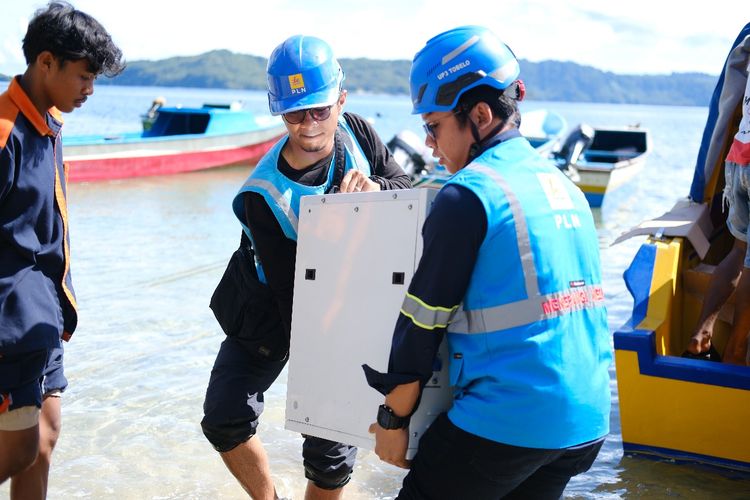 Petugas PLN ketika menurunkan material SuperSun dari kapal untuk dapat dipasang di sekolah SMP Negeri Satu Atap di Pulau Bobale, Maluku Utara.