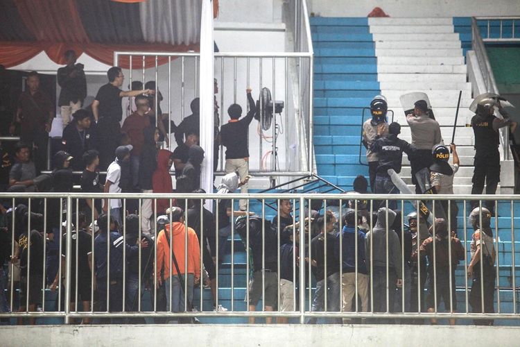 Polisi menghalau pendukung yang ricuh saat pertandingan Liga 1 antara PSS Sleman melawan Arema FC di Stadion Maguwoharjo, Sleman, DI Yogyakarta, Kamis (15/5/2019). Laga pembuka Liga 1 yang diwarnai kericuhan dan sempat dihentikan sementara itu berakhir dengan kemenangan PSS Sleman dengan skor 3-1.