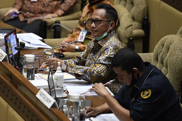 Menteri Dalam Negeri Tito Karnavian (kiri) bersama Ketua Dewan Kehormatan Penyelenggara Pemilu (DKPP) Muhammad (kanan) mengikuti Rapat Kerja dengan Komisi II DPR di Kompleks Parlemen Senayan, Jakarta, Rabu (24/6/2020). Rapat tersebut membahas pembicaraan pendahuluan RAPBN TA 2021, rencana kerja pemerintah serta upaya dan kinerja pemerintah daerah dalam menangani pandemi COVID-19. ANTARA FOTO/Puspa Perwitasari/aww.