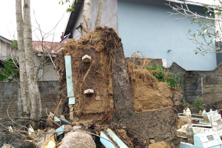 Salah satu makam yang terangkat akibat terbawa akar pohon yang tumbang karena angin kencang yang melanda Pontianak pada Senin (4/12/2017) siang.