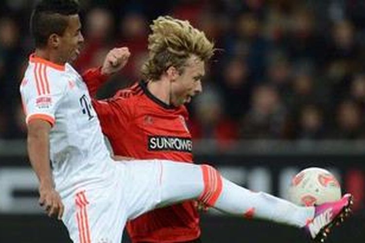 Gelandang Bayer Leverkusen, Simon Rolfes (kanan), berebut bola dengan gelandang Bayern Muenchen, Luis Gustavo Dias, pada lanjutan Bundesliga, di BayArena, Leverkusen, Sabtu (16/3/2013). 