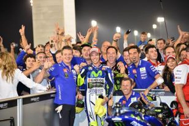 Pebalap Movistar Yamaha asal Italia, Valentino Rossi (tengah), berpose bersama tim setelah memenangi GP Qatar di Sirkuit Losail, Minggu (29/3/2015).