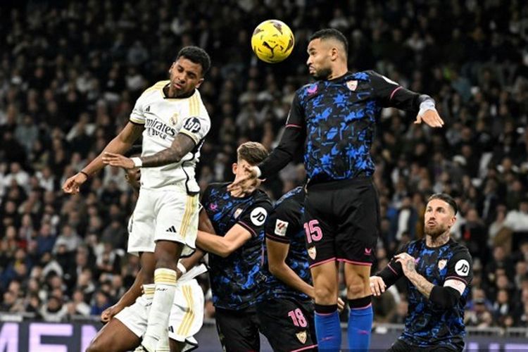 Penyerang Real Madrid, Rodryggo, melompat untuk menyundul bola dan berduel dengan pemain Sevilla, Youssef En-Nesyri, dalam lanjutan Liga Spanyol 2023-2024 antara Madrid vs Sevilla di Stadion Santiago Bernabeu pada 25 Februari 2024.