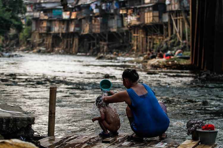 Warga beraktivitas di pemukiman padat penduduk di bantaran Sungai Ciliwung, Manggarai, Jakarta, Minggu (28/7/2019). Berdasarkan data BPS, jumlah penduduk miskin Indonesia pada periode September 2020 mencapai 27,55 juta orang.