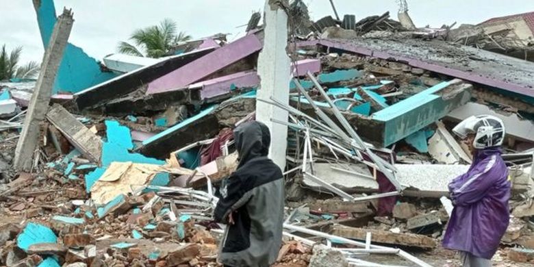 Locals of the West Sulawesi city of Mamuju stand in front of the ruins of the Mitra Manakarra Hospital after a 6.2 Richter scale earthquake hit the city and the eponymously named Mamuju Regency as well as the neighboring regency of Majene on Friday (15/1/21). The earthquake killed 84 people and injured more than 900 others