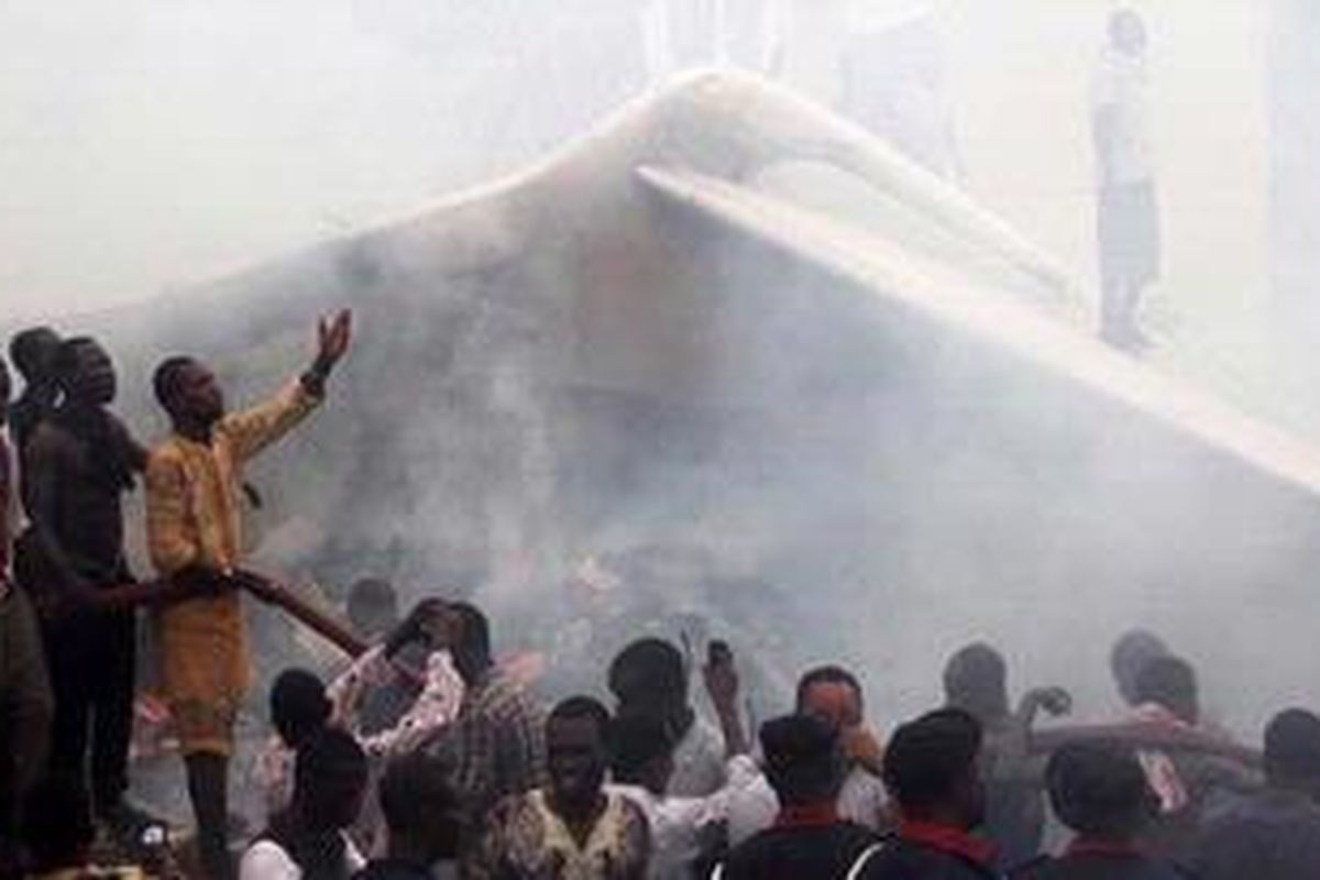 Warga berkerumun di lokasi kecelakaan pesawat Dana Air di Lagos, Nigeria, Minggu (3/6/2012). Kecelakaan itu menewaskan 153 penumpang dan awak pesawat serta puluhan orang yang berada di dalam gedung yang ditimpa pesawat tersebut.
