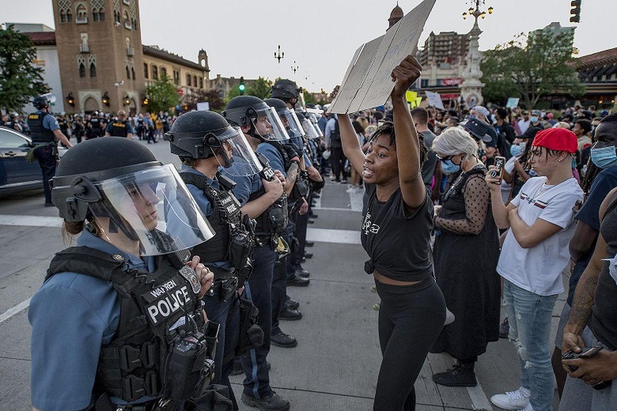 Dalam foto 29 Mei 2020 ini, seorang wanita memegang plakat unjuk rasa ketika dia berteriak Anda tidak punya wewenang untuk membunuh kaum minoritas, di Kepolisian Kota Kansas selama protes melawan kebrutalan polisi dan kematian George Floyd di Country Club Plaza di Kota Kansas.