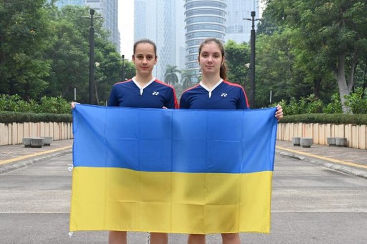 Foto yang diambil pada 15 Juni 2022 ini memperlihatkan pebulu tangkis ganda putri Ukraina Yelyzaveta Zharka (kiri) dan Mariia Stoliarenko berpose dengan bendera nasional mereka di Jakarta, Indonesia. Mereka termasuk pebulu tangkis yang mengikuti turnamen Indonesia Open 2022.