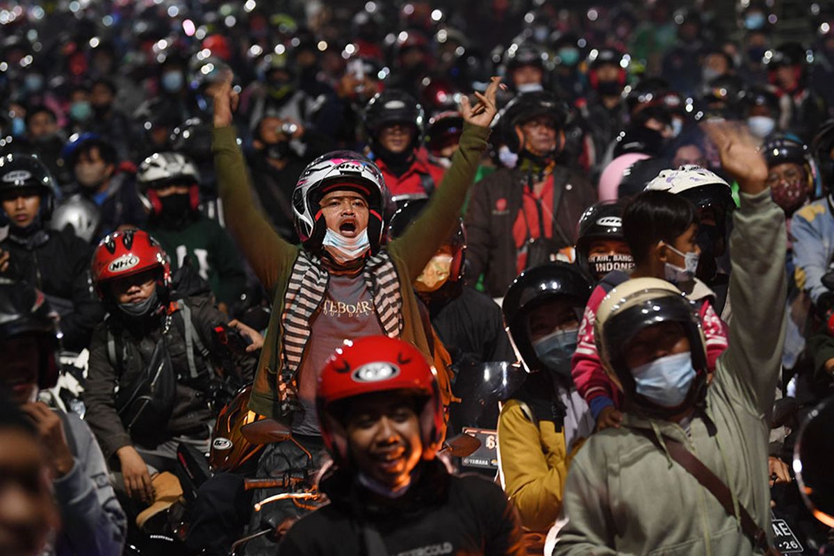 Homecoming travelers using motorbikes are stuck in traffic while crossing the security checkpoint in Kedungwaringin, Bekasi Regency, West Java, Monday (10/5/2021).