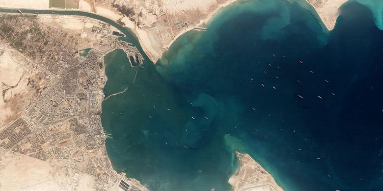 Foto ini, diambil oleh salah satu satelit pencitraan milik perusahaan Planet yang bernama Dove pada 25 Maret. Gambar menunjukkan kapal kontainer Ever Given terjebak di Terusan Suez (kiri atas) dan antrian kapal yang menunggu untuk memasuki kanal dari Laut Merah. 