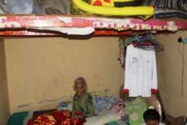 Mak Enih dan anaknya harus tinggal di kamar kontrakan yang kecil karena rumah mereka sudah terendam air Bendungan Jatigede sedangkan rumah di tempat relokasi belum dibangun.