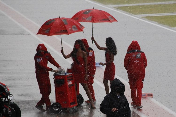 Momen ketika umbrella girl memayungi kru dari tim Ducati menjelang balapan MotoGP Mandalika, Minggu (20/3/2022) sore Wita.
