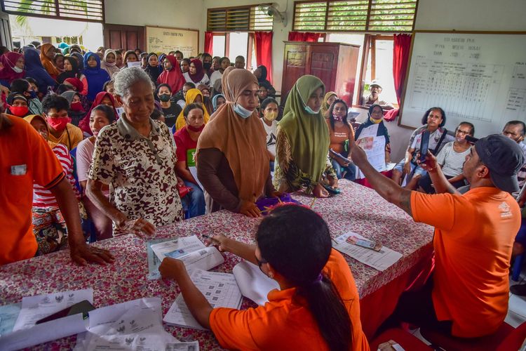 Sejumlah petugas Kantor Pos melayani ratusan warga penerima bantuan sosial atau Bansos di kantor Negeri Waai, Kabupaten Maluku Tengah, Provinsi Maluku, Kamis (14/4/2022). Pemerintah melalui Kementerian Sosial pada April 2022 mulai menyalurkan Bansos Kartu Sembako atau Bantuan Pangan Non Tunai (BPNT) kepada setiap keluarga penerima manfaat sebesar Rp200.000, dan juga Bantuan Langsung Tunai Subsidi minyak goreng Rp300.000 untuk tiga bulan periode April-Juni 2022.