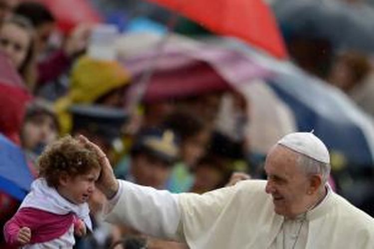 Paus Fransiskus memberkati seorang bocah saat tiba untuk pertemuan umum mingguan di Alun-alun St Peter di Vatikan, 9 Oktober 2013.