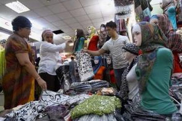 Pengunjung memilih pasmina yang dijual salah satu pedagang di pusat perbelanjaan Thamrin City, Jakarta Pusat, Kamis (25/7/2013). Warga mulai berbelanja pakaian untuk Lebaran.