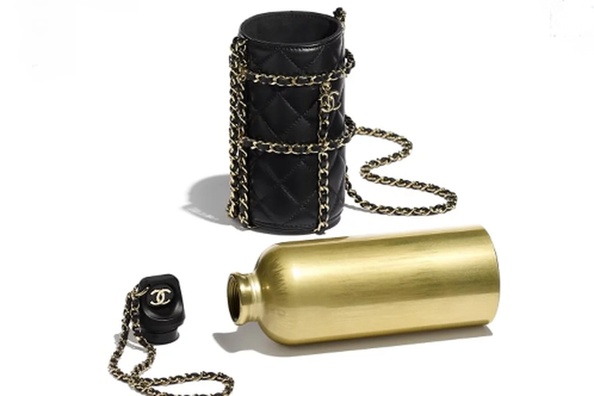 Tas wadah botol Chanel dibuat dengan bahan kulit domba berwarna hitam yang dipadukan dengan rantai berwarna emas, senada dengan botol di dalamnya.