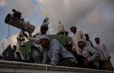 Petugas Lembaga Falakiyah Pondok Pesantren Al-Hidayah Basmol, Jakarta Barat melakukan pemantauan hilal di atas Masjid Al-Musariin, Minggu (5/5/2019).