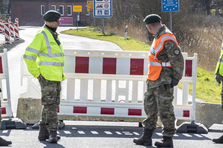 Petugas menjaga perbatasan di Aventoft, Jerman, dekat Tonder, Denmark, pada 14 Maret 2020.