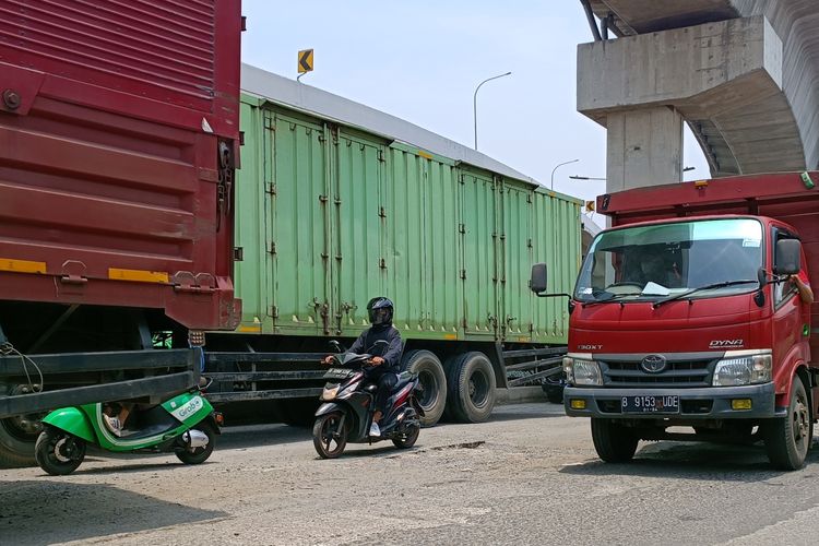 Jalan Raya Bekasi arah Cakung menuju Pulo Gebang di Jakarta Timur, tepatnya di dekat pintu masuk Tol Cakung, dalam keadaan penuh lubang, Senin (13/3/2023).