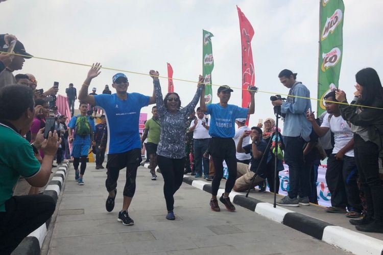 Wakil Gubernur DKI Jakarta Sandiaga Uno dan Menteri Kelautan dan Perikanan Susi Pudjiastuti saat finis dalam Tidung Aquathlon, Sabtu (5/5/2018). 