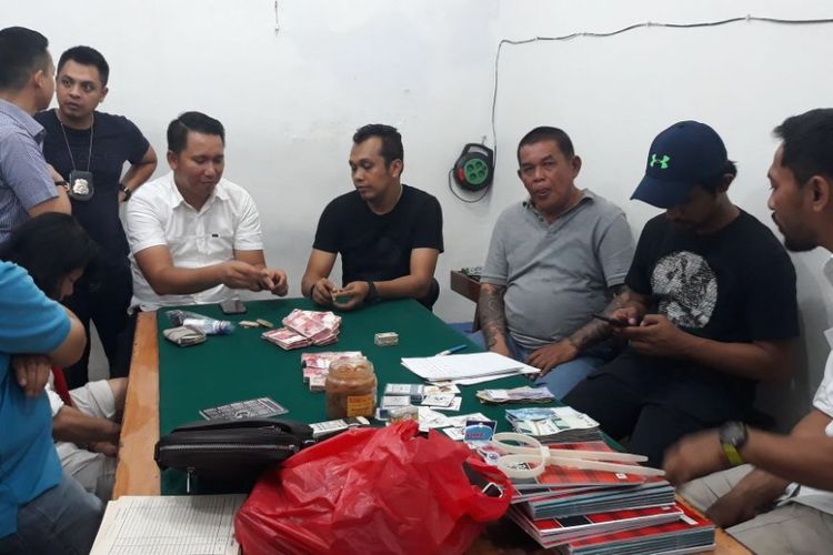 Polisi menggerebek dua rumah judi di Jalan Dwi Warna 8, Gang C Nomor 42, Sawah Besar, Jakarta Pusat, Senin (12/3/2018) malam. 87 penjudi diamankan dia dua rumah tersebut