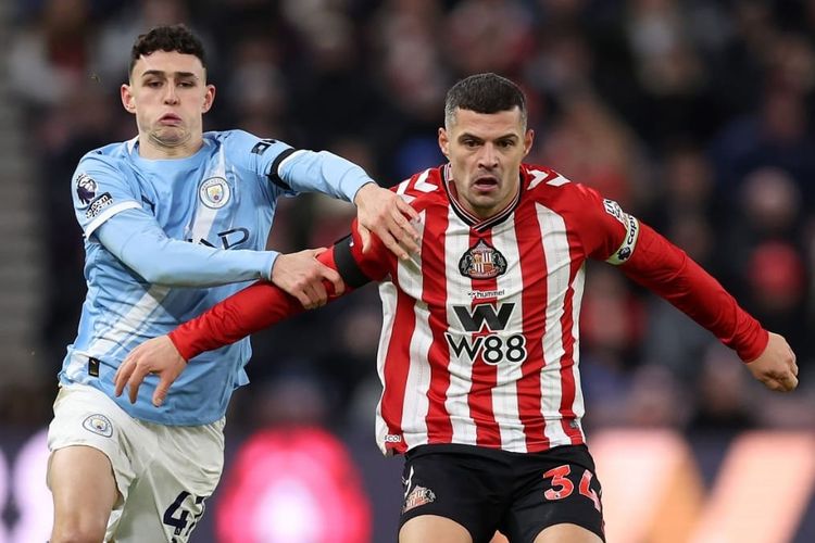 Gelandang Manchester City, Phil Foden, berduel dengan gelandang Sunderland, Granit Xhaka, dalam lanjutan Premier League