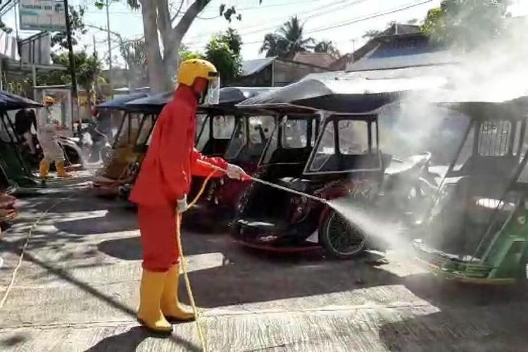 Dua orang petugas dari PMI Provinsi Gorontalo melakukan penyemprotan cairan disinfektan ke ribuan bentor yang beroperasi di Kota Gorontalo, Jumat (5/6/2020). Penyemprotan yang dilakukan secara bergantian itu diharapkan bisa menjaga kebersihan bentor dan mencegah penularan virus corona.