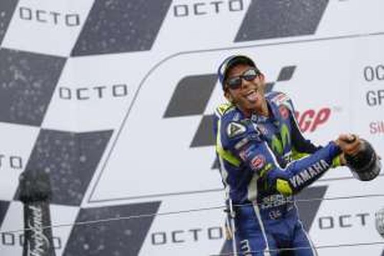 Pebalap Movistar Yamaha asal Italia, Valentino Rossi, menyemprotkan sampanye untuk merayakan keberhasilannya finis di urutan kedua pada balapan GP Inggris di Sirkuit Silverstone, Minggu (4/9/2016).