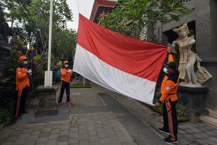 Tim Reaksi Cepat dan Satgas Covid-19 Tangguh Dewata mengibarkan bendera merah putih saat memperingati HUT Ke-76 Republik Indonesia di halaman Kantor Desa Sumerta Kelod, Denpasar, Bali, Selasa (17/8/2021). Kegiatan yang digelar secara sederhana tersebut untuk memperingati HUT RI dan mengenang perjuangan para pahlawan yang berhasil merebut kemerdekaan sekaligus membangkitkan semangat dalam upaya mengatasi pandemi Covid-19.