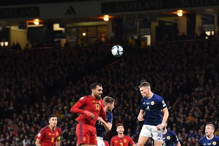 Scott McTominay (kanan) saat menyundul bola dalam pertandingan Skotlandia vs Spanyol pada lanjutan fase grup kualifikasi Euro 2024 di Hampden Park, Glasgow, Rabu (29/3/2023) dini hari WIB. Laga Skotlandia vs Spanyol tuntas dengan skor 2-0. (Foto oleh ANDY BUCHANAN / AFP)