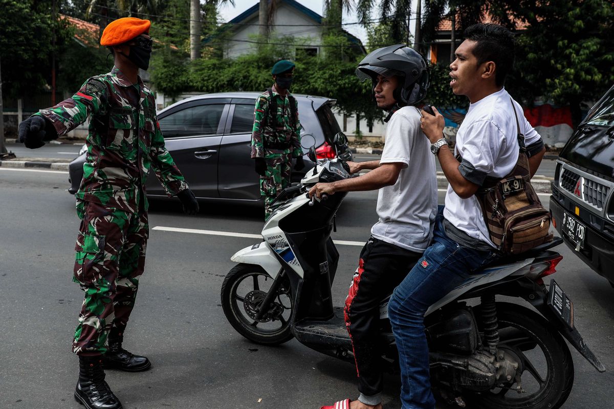 Petugas gabungan dari TNI, Polri, Polisi Pamong Praja dan Dishub DKI Jakarta melakukan imbauan kepada pengendara motor untuk dapat mematuhi penerapan Pembatasan Sosial Berskala Besar (PSBB) di jalan Penjernihan, Tanah Abang, Jakarta Pusat, Senin (13/4/2020). Imbauan ini dilakukan agar masyarakat menerapkan pembatasan sosial berskala besar (PSBB) selama 14 hari, yang salah satu aturannya adalah pembatasan penumpang kendaraan serta anjuran untuk menggunakan masker jika berkendara.