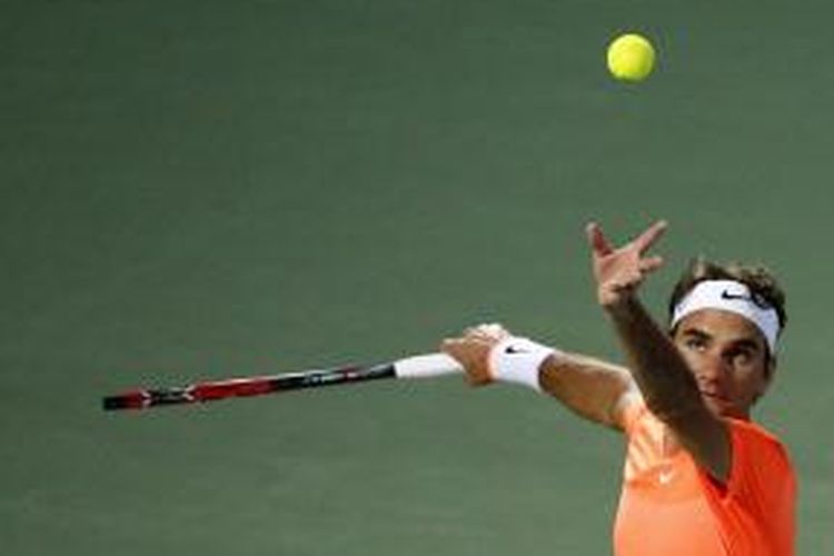 Petenis Swiss, Roger Federer, melakukan servis saat menghadapi petenis Spanyol, Fernando Verdasco, pada babak kedua Duty Free Tennis Championships, Rabu (25/2/2015).