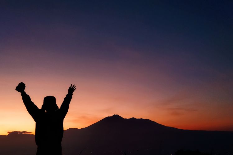 Seorang wisatawan tengah menikmati pemandangan Gunung Gede Pangrango detik-detik menjelang momen golden sunrise yang dilihat dari Desa Pasirjaya, Kecamatan Cigombong, Kabupaten Bogor pada Kamis (27/5/2021).