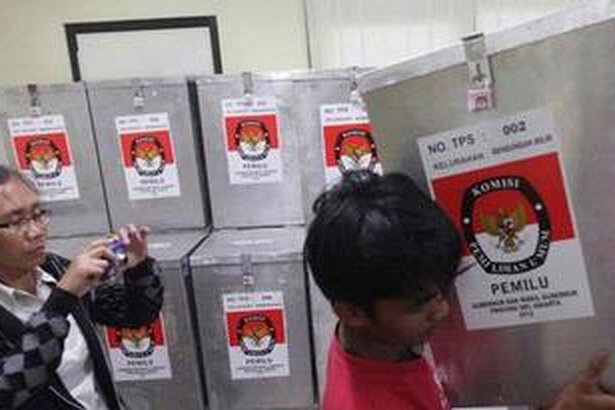 Petugas Panitia Pemungutan Sura (PPS) Kelurahan Bendungan Hilir, Jakarta Pusat, mengangkat kotak suara yang akan dihitung perolehan suaranya di tingkat PPS, Kamis (12/7/2012).  