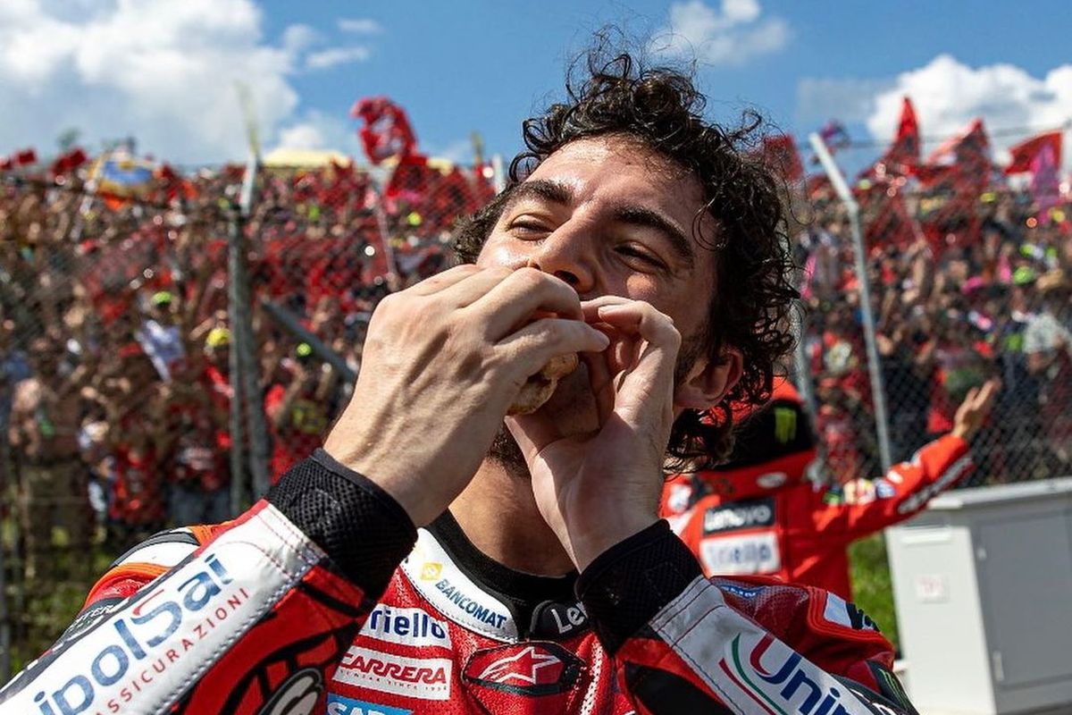 Selebrasi Francesco Bagnaia makan hot dog di pinggir trek, setelah menang pada MotoGP Italia 2023 di Sirkuit Mugello