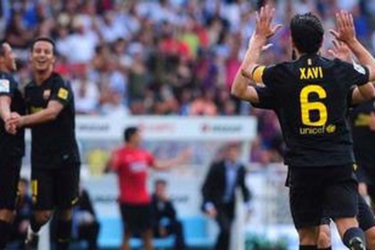 Gelandang Barcelona, Xavi Hernandez (kanan), merayakan golnya ke gawang Real Sociedad, dalam lanjutan Liga BBVA, Sabtu (10/9/2011).