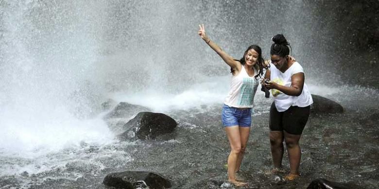 Wisatawan mengunjungi air terjun Sendang Gile di kaki Gunung Rinjani, Desa Senaru, Kecamatan Bayan, Lombok Utara, Nusa Tenggara Barat, Rabu (27/1/2016). Sendang Gile menjadi salah satu situs geologi Gunung Rinjani yang mendukung dijadikannya Gunung Rinjani sebagai taman bumi (geopark) dunia. 