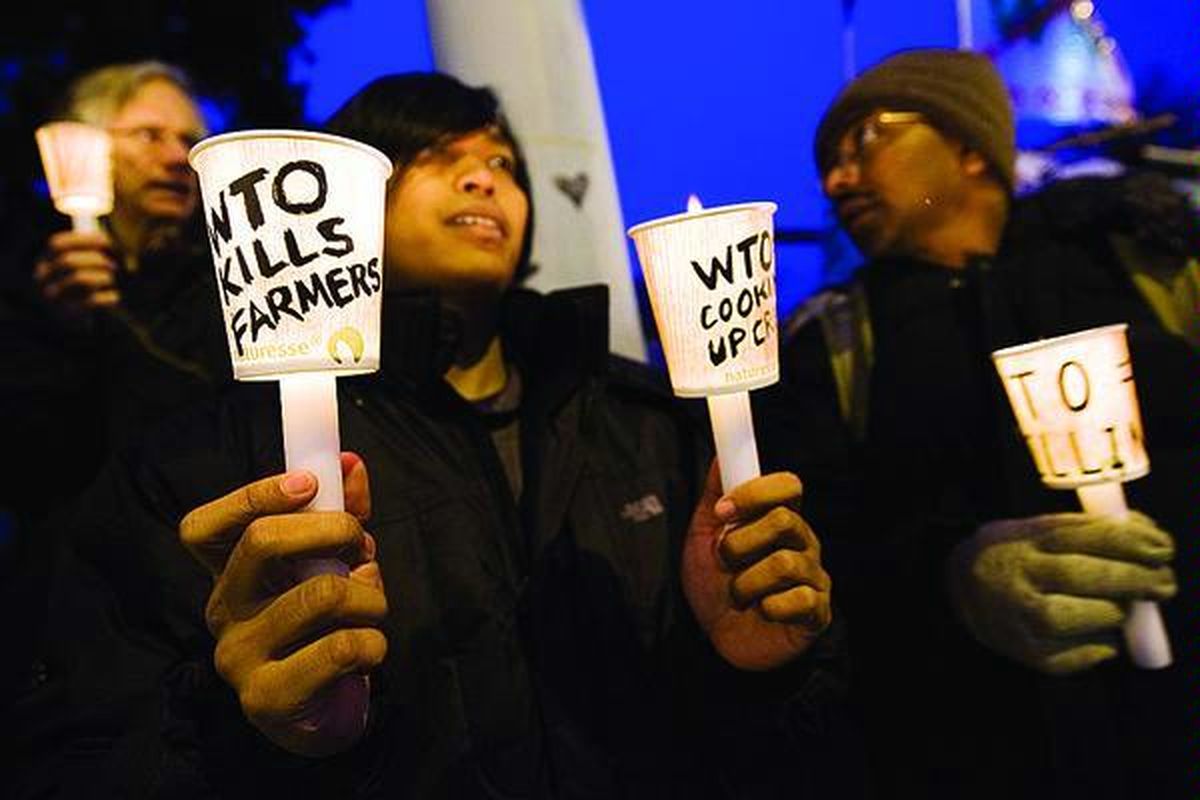 Para demonstran melakukan protes dengan menyalakan lilin pada pembukaan Pertemuan Tingkat Menteri Organisasi Perdagangan Dunia (WTO) Ke-7 di Geneva, Swiss, 30 November 2009.