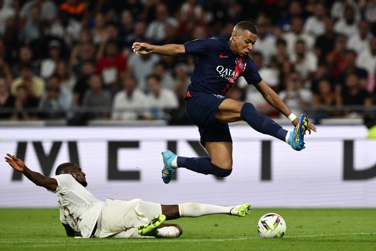 Penyerang Paris Saint-Germain Kylian Mbappe (kanan) menghindari tekel bek Lyon, Clinton Mata pada pertandingan Ligue 1 Perancis antara Lyon vs PSG di Stadion Groupama di Decines-Charpieu, Perancis timur tengah, pada 3 September 2023. (Foto oleh Jeff PACHOUD / AFP)
?